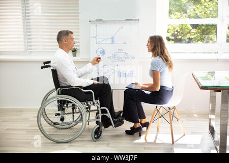 Deaktiviert gereift, Geschäftsmann, Diagramm, während sie eine Präsentation zu seinen Kollegen im Büro Stockfoto