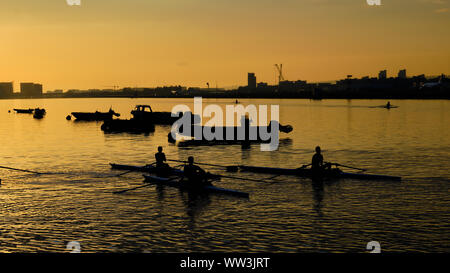 Abgebildet sind Kanuten bei Sonnenaufgang auf der Themse in London City Airport Stockfoto