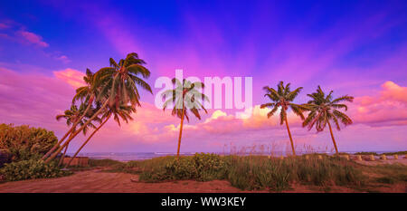 Eine bunte in den Westen taucht die Wolken über dem Ozean im Osten mit lebendigen und brillante Farben. Stockfoto