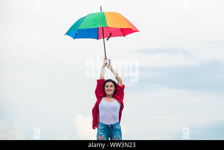 Fallschirm Konzept. Gutes Wetter. Einladende fallen. Hübsche Frau mit bunten Regenschirm. Regenbogen Regenschirm. Regenwetter. Gute Laune. Gute Laune. Aufgeschlossene Person. Mädchen das Gefühl gut Himmel Hintergrund. Stockfoto