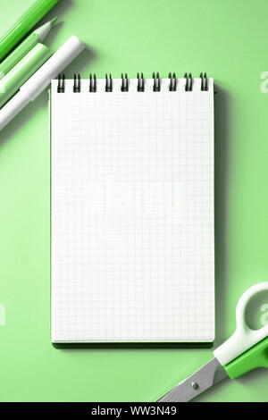 Verschiedene Schreibwaren und leer Notebook auf einer frischen und trendigen Minze Hintergrund. Zurück zum Konzept der Schule. Bis Mock, Flach, senkrecht. Stockfoto