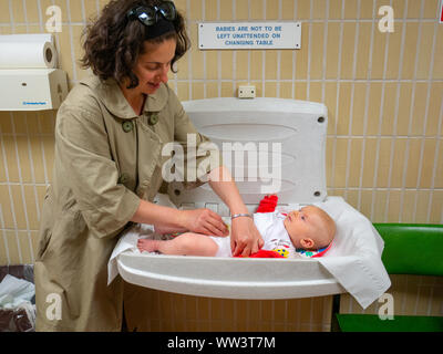 Baby in Windel auf Wickeltisch in öffentlichen Toiletten geändert, Großbritannien Stockfoto