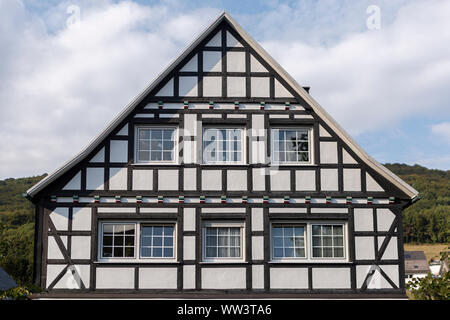 Architektonisches Detail der typischen Fachwerkhäuser Vakwerk Wohnungen im Kurort Grafschaft im Sauerland in Deutschland bei Sonnenuntergang mit Wolken Stockfoto