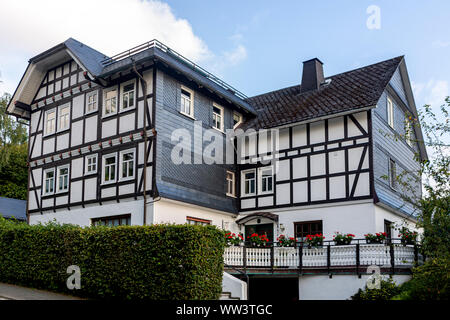 Architektur der typischen Fachwerkhäuser Vakwerk Wohnungen im Kurort Grafschaft im Sauerland in Deutschland gegen einen blauen Himmel mit Wolken Stockfoto