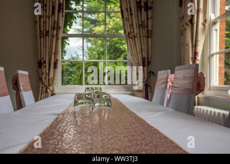 Innenraum der elegante Speisesaal. Tabelle mit wenigen Trinkgläser und hellen Fenstern im Hintergrund Stockfoto