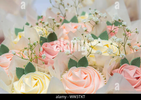 Wunderschön eingerichtete Hochzeit rose Cupcakes in Pastelltönen mit glitzerndem Zucker Stockfoto