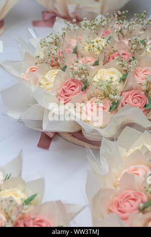 Wunderschön eingerichtete Hochzeit rose Cupcakes in Pastelltönen auf der Oberseite der Tabelle Stockfoto