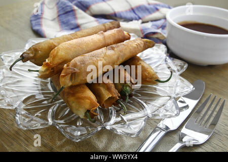 Foto von frisch zubereiteten Philippinische Spezialität, Dynamit oder gebratene grüne Chili mit Boden Schweinefleisch im Frühjahr Roll-wrapper gefüllt Stockfoto