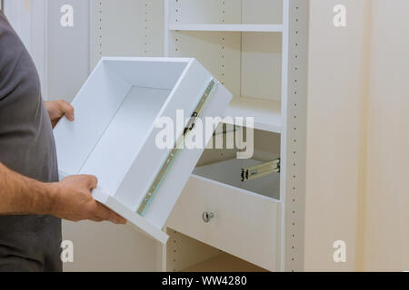 Installation der Arbeiter stellt die Schublade im Schrank Schrank Möbel im neuen Haus Stockfoto