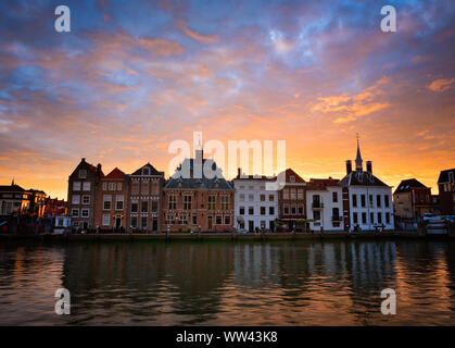 Die historische Innenstadt von Maassluis, Niederlande am Hafen entlang. Sunrise leuchtet hinter antiken alten Gebäuden. Sonnenuntergang hinter der alten Kirche. Malerische Landschaft Stockfoto