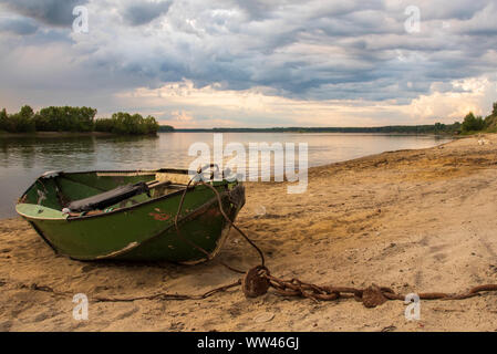 Alte, verlassene Boot, mit dem die Kette auf dem sandigen Ufer der Fluss in Sibirien, Russland. Bewölkter Himmel im Hintergrund. Stockfoto