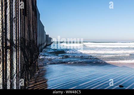 Die internationale Grenze Mauer aus in den Ozean zwischen San Diego und Tijuana, Mexiko an der Grenze Feld Park. Stockfoto