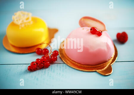 Mousse Kuchen mit Erdbeeren pürieren, Sahne und frischen Früchten auf einem blauen Hintergrund Stockfoto