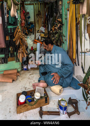 Maskat, Sultanat von Oman - 12. November 2017: Der Mann, der den Verkauf von handgefertigten Lederwaren im Souq in Salalah, Oman, Indischen Ozean. Stockfoto