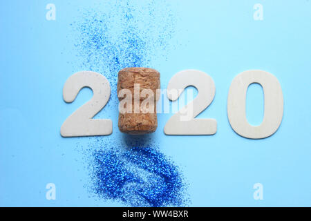 2020. Die Zahlen 2020 und Kork aus der Champagne auf einem blauen Hintergrund um den Schneeflocken und Blau glitter isoliert. Stockfoto