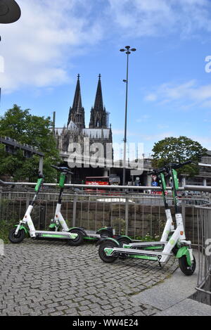 Köln, Deutschland. 12 Sep, 2019. E Roller durch Kalk stehen auf der Straße mit Blick auf den Kölner Dom Bild: Horst Galuschka/dpa/Alamy leben Nachrichten Stockfoto