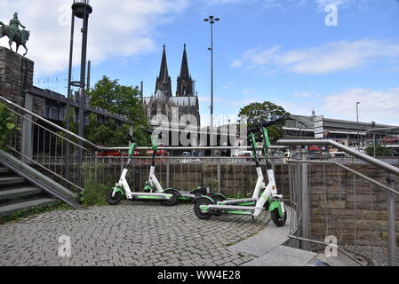 Köln, Deutschland. 12 Sep, 2019. E Roller durch Kalk stehen auf der Straße mit Blick auf den Kölner Dom Bild: Horst Galuschka/dpa/Alamy leben Nachrichten Stockfoto