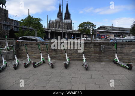 Köln, Deutschland. 12 Sep, 2019. E Roller durch Kalk stehen auf der Straße mit Blick auf den Kölner Dom Bild: Horst Galuschka/dpa/Alamy leben Nachrichten Stockfoto