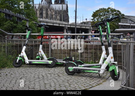 Köln, Deutschland. 12 Sep, 2019. E Roller durch Kalk stehen auf der Straße mit Blick auf den Kölner Dom Bild: Horst Galuschka/dpa/Alamy leben Nachrichten Stockfoto