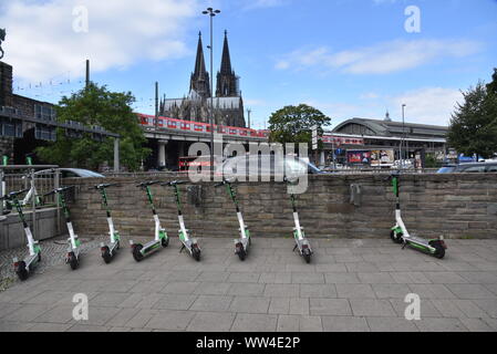 Köln, Deutschland. 12 Sep, 2019. E Roller durch Kalk stehen auf der Straße mit Blick auf den Kölner Dom Bild: Horst Galuschka/dpa/Alamy leben Nachrichten Stockfoto