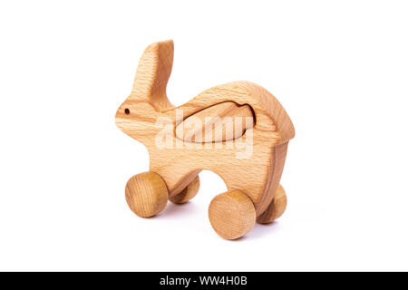 Foto von einem hölzernen Hase mit Karotte auf Rädern der Buche. Spielzeug aus Holz auf einem weißen Hintergrund isoliert. ein Spielzeug für die Unterhaltung der Kinder und ruht aus. Stockfoto