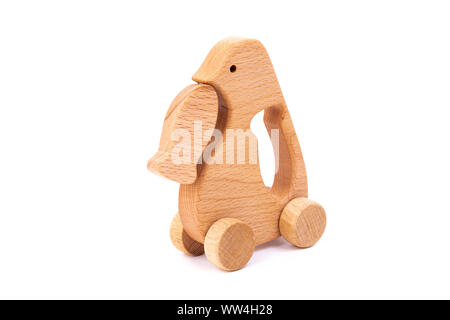 Foto von einem hölzernen Pinguin mit Fisch auf Rädern der Buche. Spielzeug aus Holz auf einem weißen Hintergrund isoliert. ein Spielzeug für die Unterhaltung der Kinder und ruht aus. Stockfoto