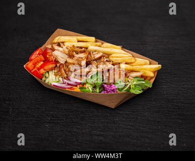 Griechische gyros Teller mit Pommes frites und Gemüse in Papier Platte Stockfoto