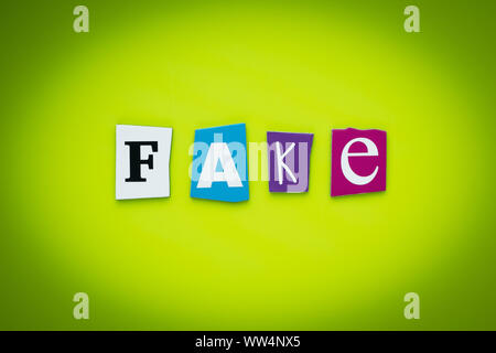 Wort-fake. Text auf gelben und grünen Hintergrund. Nachricht auf einem Plakat. Cutted bunte Buchstaben. Schlagzeile auf hellen Karte. Mehrfarbige Beschriftung o Stockfoto