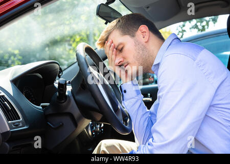 Mann schiefen Kopf auf das Lenkrad im Auto Stockfoto