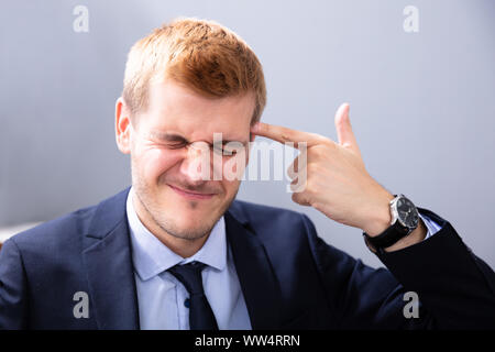 Mann, der schießen Geste mit seiner Hand im Amt Stockfoto