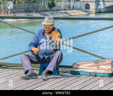 Paris, Frankreich, 4. Juli 2017: Alter Mann auf einem Stuhl spielen Geige auf Tipps für die Pont des Arts Fußgängerbrücke über die Seine in Paris. Stockfoto