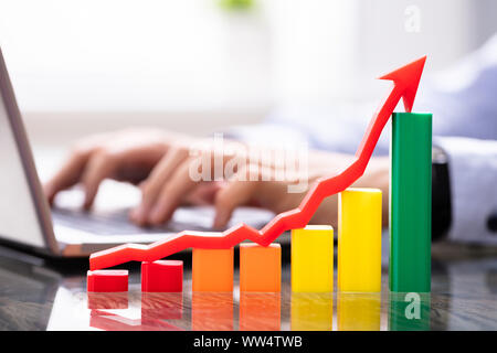 Wachstumsdiagramm in der Nähe der Mann bei der Arbeit am Laptop Stockfoto