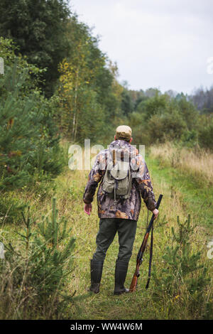 Jäger mit einen Rucksack und eine Jagd Gewehr in den Wald. Stockfoto