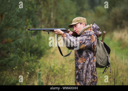 Jäger mit einen Rucksack und eine Jagd Gewehr in den Wald. Stockfoto