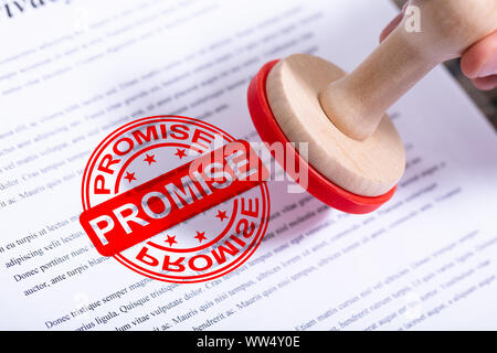 Geschäftsmann Hand versprechen Stempel auf Dokument Stockfoto