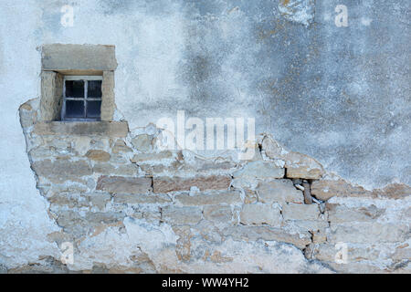 Alten heruntergekommenen Haus Wand mit einem kleinen Fenster Stockfoto
