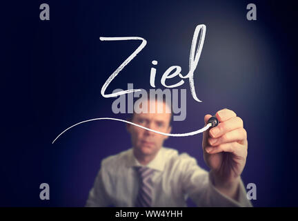 Ein Geschäftsmann schreiben ein Ziel 'Ziel'-Konzept in deutscher Sprache mit einem weißen Stift auf einem Bildschirm löschen. Stockfoto