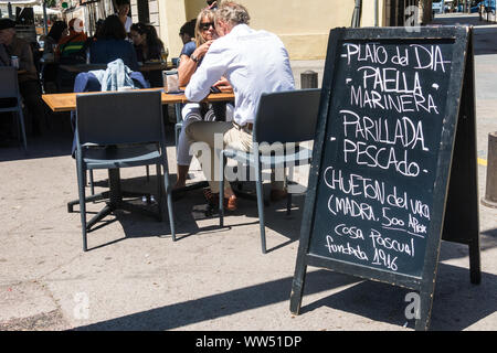 Barcelona, Spanien - 10. Mai 2019: Touristen essen in der Barceloneta, der küstenstadt Viertel von Barcelona. Der Vorstand kündigt eafood Paella, gegrilltes Stockfoto