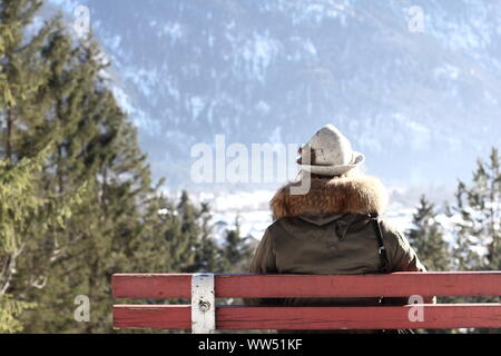 Junge Frau mit traditionellen bayerischen Hut und Pelzkragen im Alpenpanorama, Stockfoto