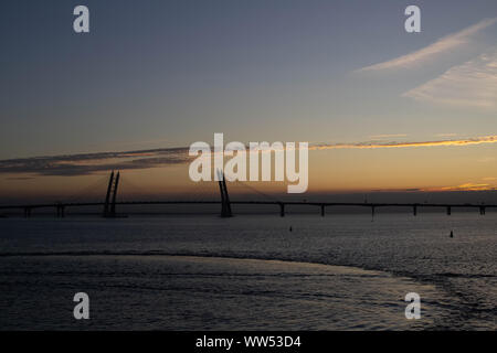 Lange Schrägseilbrücke über den Hintergrund von einem schönen Sonnenuntergang auf dem Meer Stockfoto