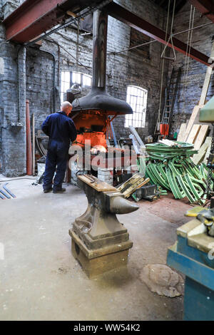 Ein Schmied in seiner Schmiede bei John Taylor & Unternehmen Glockengießerei, Loughborough, Leicestershire, England, UK arbeiten Stockfoto
