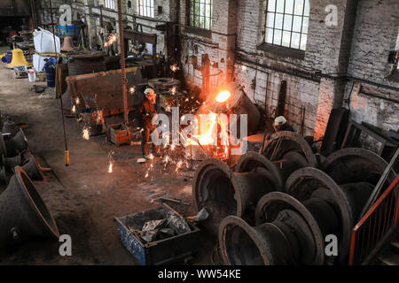 Funken aus einem Kessel mit red hot Metallschmelze in der Gießerei bei John Taylor & Unternehmen Glockengießerei, Loughborough, Leicestershire, England, Großbritannien Stockfoto