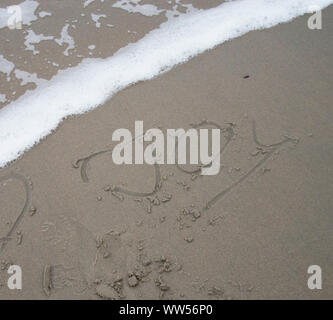 Wort Freude in Sand vor der kleinen Welle Stockfoto