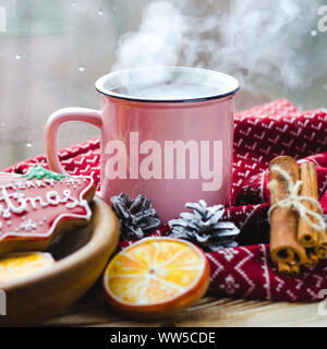Eine heiße Tasse Tee steht auf einem hölzernen Tisch neben einem hölzernen Platte auf die Lebkuchen Cookies von orange Schnitte vor dem Hintergrund einer Stockfoto