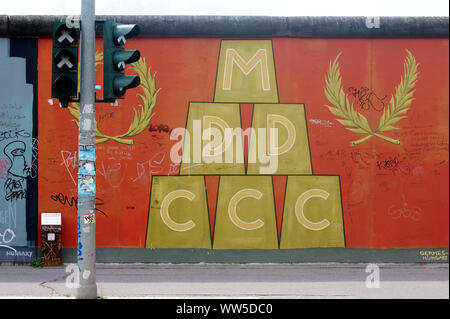 Eine stillgelegte Ampel vor einem Kunstwerk von der East Side Gallery in Berlin. Stockfoto