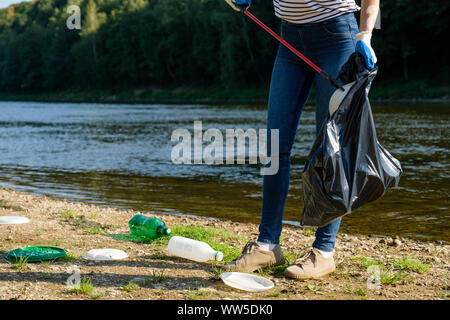 Freiwillige Frau herauf Plastikmüll am Strand. Reinigung Umwelt Konzept Stockfoto