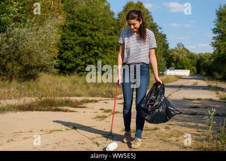 Freiwillige Frau herauf plastik Müll im Wald. Reinigung Umwelt Konzept Stockfoto