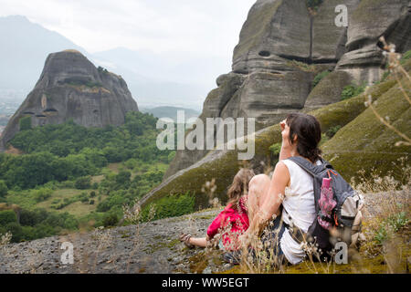 Panoramabild der felsigen Landschaft rund um Meteora mit Frau und Kind sitzen auf Leiste Stockfoto