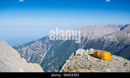 Orange Zelt auf einem Berg Kante auf einem Plateau in den Bergen mit Blick auf das Meer Stockfoto