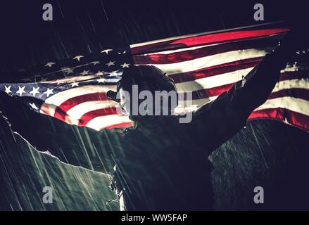 Stolz der amerikanischen Armee Soldat mit National Flagge in den Händen während Schweres Gewitter und Niederschlag. Die Vereinigten Staaten von Amerika. Sieg Konzept. Militärische. Stockfoto
